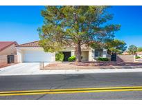 Charming single-story home featuring a well-manicured lawn, mature tree, and a two-car garage at 8813 Sundial Dr, Las Vegas, NV 89134