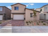 Two-story home featuring a red brick driveway, two car garage, and desert landscaping at 9283 Lunar Phase St, Las Vegas, NV 89143