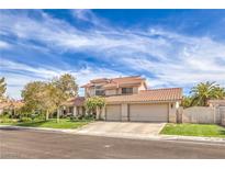 Charming two-story home boasts a three-car garage and manicured front lawn with mature trees at 1009 Nawkee Dr, North Las Vegas, NV 89031