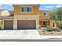 Two-story home with a three-car garage, desert landscaping, and a tan and brown color palette at 1776 Gentle Brook St, North Las Vegas, NV 89084