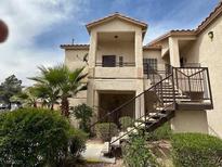 Multi-level exterior of a stucco condo building with stairs, balconies, and desert landscaping at 1830 N Buffalo Dr # 2098, Las Vegas, NV 89128