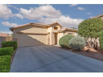Charming single-story home with a two-car garage, desert landscaping, and a tile roof under a partly cloudy sky at 5049 Running Rapids Ave, Las Vegas, NV 89130