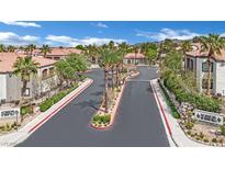 Community street with palm trees and a view of well-maintained townhomes in a desert environment at 950 Seven Hills Dr # 124, Henderson, NV 89052