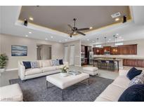 Open-concept living room showcasing modern furnishings and decor, plus an adjacent kitchen with a breakfast bar at 11274 Felice Cohn Ct, Las Vegas, NV 89179