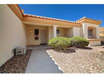 Inviting single-story home featuring a tiled roof and a covered entryway with decorative shrubs at 3021 Lotus Hill Dr, Las Vegas, NV 89134