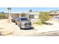 Modest single-story home featuring a simple design, desert landscaping, and a parked truck at 3137 Crawford St, North Las Vegas, NV 89030