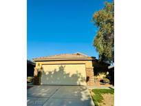 This home features a two-car garage with a concrete driveway and desert landscaping at 3538 Old Course St, Las Vegas, NV 89122