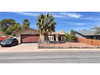 Charming single-story home features a two-car garage and desert landscaping with a secure chain link fence at 625 Fernbrook Dr, Henderson, NV 89002