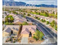 Expansive aerial view of the home in a lovely community with desert landscaping and mountain views at 7556 Wingspread St, North Las Vegas, NV 89084