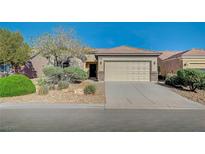 Inviting single-story home with desert landscaping and a two-car attached garage at 7760 Pine Warbler Way, North Las Vegas, NV 89084