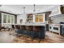 Spacious kitchen features a large center island with bar seating, white cabinetry, and professional-grade stainless steel appliances at 8537 Eureka Heights Ct, Las Vegas, NV 89178
