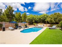 A refreshing pool area with lounge chairs and a manicured lawn provides a relaxing outdoor oasis at 11244 Playa Caribe Ave, Las Vegas, NV 89138