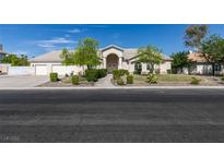 Inviting single-story home with a three-car garage, lush landscaping, and a welcoming front entrance at 1341 Marina Del Rey Ct, Las Vegas, NV 89117