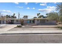 Charming single-story home showcasing xeriscaping, palm trees and a turquoise front door at 2205 Sombrero Dr, Las Vegas, NV 89169