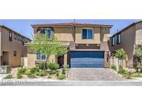 Two-story home featuring a blue garage door, well-maintained landscaping, and manicured lawn at 5317 Golden Melody Ln, North Las Vegas, NV 89081