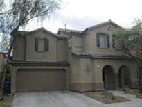 Two story home showcasing the garage and an arched entryway at 7173 Las Colinas Ave, Las Vegas, NV 89179