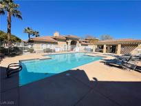 Beautiful pool with ample seating and a building in the background on a sunny day at 833 Aspen Peak Loop # 1021, Henderson, NV 89011