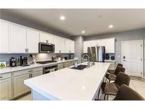 Modern kitchen features a large island with quartz countertops and stainless steel appliances at 10372 Thurso Ave, Las Vegas, NV 89166