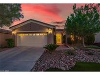 Inviting single-story home showcasing a tidy front yard and a convenient two-car garage at sunset at 10581 Santo Marco Ct, Las Vegas, NV 89135