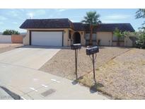 Single-story home featuring desert landscaping, a two-car garage, and a unique roof at 230 Queen Marie Ct, Henderson, NV 89015