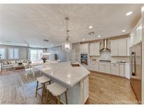 Bright, open kitchen with white cabinets, stainless steel appliances, and a large center island with seating at 2767 Flowing Breeze St, Henderson, NV 89044