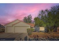 Charming single-story home with a two-car garage, desert landscaping, and vibrant sunset sky at 4620 Standing Bluff Way, Las Vegas, NV 89130