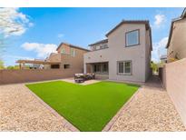 Backyard features an artificial lawn, patio with comfortable outdoor seating, and a privacy wall at 7132 Sayonara Vista St, North Las Vegas, NV 89084