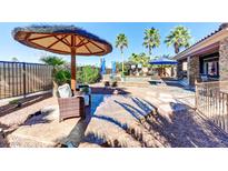 Beautiful backyard pool area with an umbrella-covered seating area, perfect for outdoor relaxation and entertaining at 8209 Chapelle Ct, Las Vegas, NV 89131