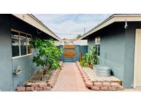 Charming backyard space with a brick pathway, lush greenery, and stylish fencing, creating a private outdoor oasis at 1801 Griffith Ave, Las Vegas, NV 89104