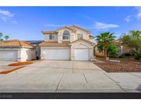 Inviting two-story home with attached two-car garage and a charming desert landscape at 9021 Canyon Magic Ave, Las Vegas, NV 89129