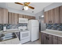An updated kitchen with stainless steel appliances, stylish cabinets, and modern backsplash at 1643 E St, Las Vegas, NV 89106