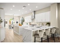 Bright kitchen with white cabinets, stainless steel appliances, and a large island with a marble waterfall countertop at 2264 Savannah River St, Henderson, NV 89044