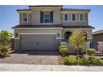 Charming two-story home featuring a brick driveway, two-car garage, and manicured landscaping at 2581 Tolmezzo St, Henderson, NV 89044