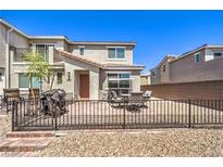 Brick backyard with dining set, grill, and black metal fencing at 2657 Fawn Beige Ct, North Las Vegas, NV 89086