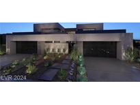 Modern home with a two-car garage, desert landscaping, and gray driveway at dusk at 611 Grand Rim Dr, Henderson, NV 89012