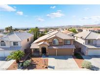 Charming two-story home boasts a well-maintained yard, arched entryway, two-car garage, and tile roof at 9785 Gallo Dr, Las Vegas, NV 89147