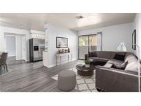 Comfortable living room features a large sectional sofa, decorative rug, and sliding glass door to outdoor balcony at 2451 N Rainbow Blvd # 1016, Las Vegas, NV 89108