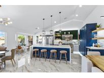 Modern kitchen with a large island, stainless steel appliances, and beautiful marble flooring at 2652 Golfside Dr, Las Vegas, NV 89134