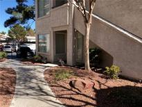 Exterior view of a light beige condo with landscaped rocks and walkway leading to stairs at 3041 Casey Dr # 101, Las Vegas, NV 89120