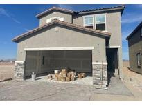 Modern two-story home with gray stucco and a spacious two-car garage featuring stone accents at 9548 Hinson St, Las Vegas, NV 89139