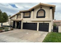 Two-story home featuring a three-car garage, stucco exterior, and arched windows at 2816 Via Bel Mondo St, Henderson, NV 89074