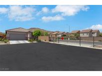 Inviting single-story home featuring desert landscaping and a neutral color palette, complemented by mountain views in the background at 703 Shiva St, Las Vegas, NV 89178