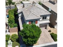 Charming two-story home with a brick driveway, lush landscaping, and well-maintained roof tiles at 7788 Ebro Valley Ct, Las Vegas, NV 89113