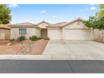 Charming single-story home with a two-car garage, desert landscaping, and a tile roof at 9539 Iris Flat Ct, Las Vegas, NV 89178