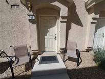 Cozy front door with a small stoop, seating, and minimalistic desert landscaping at 4624 Snake Eyes St # 101, Las Vegas, NV 89122