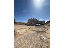 Spacious home with circular window, ample surrounding land, and a detached garage, set beneath a clear sky at 7475 Gilespie St, Las Vegas, NV 89123