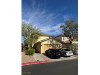 Charming two-story home featuring a tan exterior, attached garage, and low-maintenance desert landscaping at 1205 Padre Serra Ln, Las Vegas, NV 89134