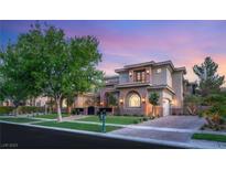 Stunning two-story home featuring stone accents, well-manicured landscaping, and a brick-paved driveway at 15 Vintage Canyon St, Las Vegas, NV 89141