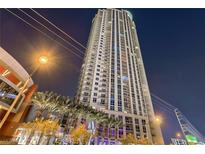 Modern high-rise building exterior at night with palm trees and attractive lighting at 200 W Sahara Ave # 2407, Las Vegas, NV 89102