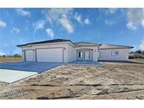 Attractive single-story home features a three-car garage, tile roof, and well-lit entryway at 2201 W Wisteria Way, Pahrump, NV 89048
